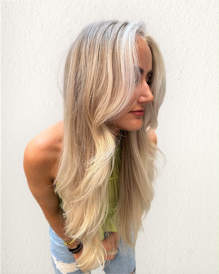 Lang blond haar met laagjes en lichte lokken rond het gezicht, gekleurd door LOQ Kappers